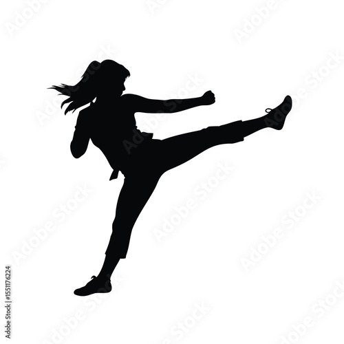 Silhouette of a woman practicing martial arts with a side kick technique
