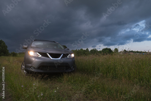 SUV in a Field Under Dramatic Skies