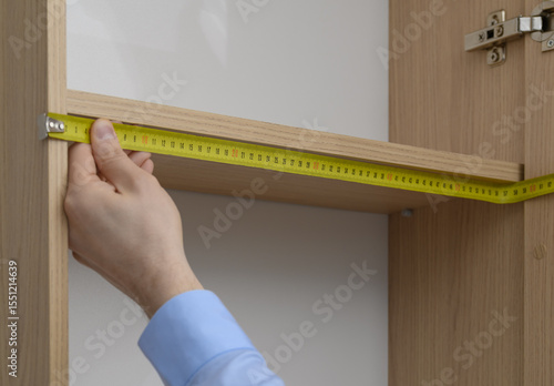 Принти на полотні A carpenter measures a shelf in a built-in wardrobe, custom-made furniture