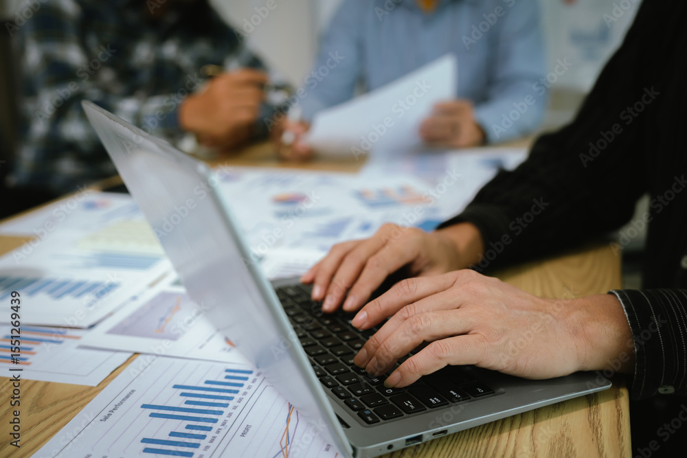 Fototapeta premium A professional business team collaborates around a conference table, analyzing charts, discussing strategies, reviewing reports, and planning innovative solutions to drive growth, efficiency, and long