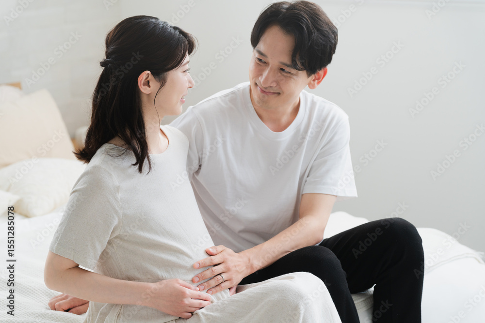 ベッドでくつろいでいる妊婦と夫 ライフスタイルイメージ ベッドでくつろいでいる妊婦と夫 ライフスタイルイメージ