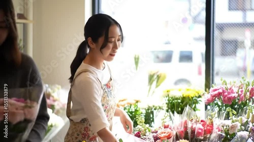 Young woman arranging flowers in a bright flower shop  