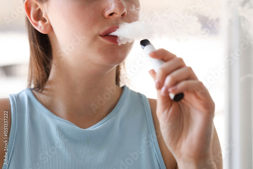 Bild auf Leinwand Young woman using electronic smoking device outdoors, closeup