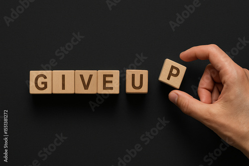Conceptual image of the phrase GIVE UP built from individual wooden cubes, symbolizing defeat, giving in, and the emotional complexity behind walking away from goals or challenges