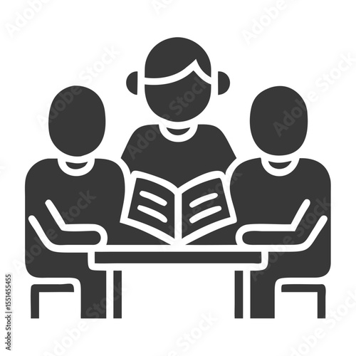 A female teacher guides two students through a reading session at a table.