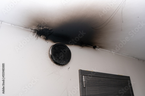 Burnt out LED lamp. A lampshade lamp on the wall after a fire. Spontaneous combustion and fire in a residential building. Indoor apartment