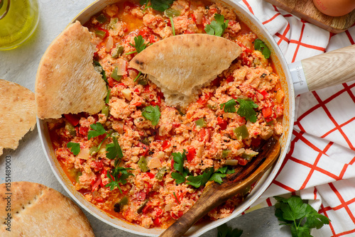 Turkish menemen fried eggs in a frying pan with pita bread. selective focus. hugge style