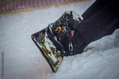 snowboarder sitting in the snow. close-up of boards and shoes.