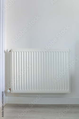 Wallpaper Mural Vertical image of a white radiator on a light wall in a clean interior, wooden floor and soft lighting create a feeling of warmth and domestic tranquility Torontodigital.ca