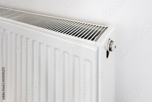 Wallpaper Mural Detailed view of a radiator with metal valve and slotted top grill, minimal home heating system against a white textured wall background Torontodigital.ca