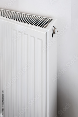 Wallpaper Mural White panel radiator with top ventilation slots and metal valve, photographed from side angle in bright minimalist interior, concept of efficient home heating Torontodigital.ca