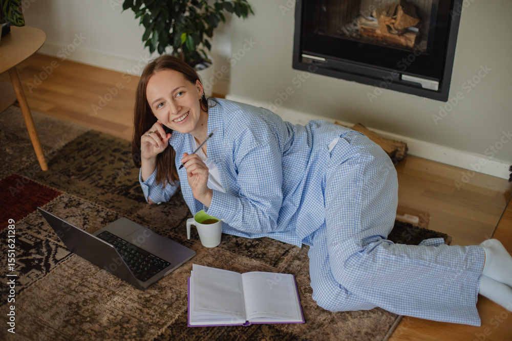 custom made wallpaper toronto digitalmage of a pretty woman working on her laptop while sitting comfortably on the floor at home. Concept of remote work, freelance lifestyle, casual productivity, and modern home office.