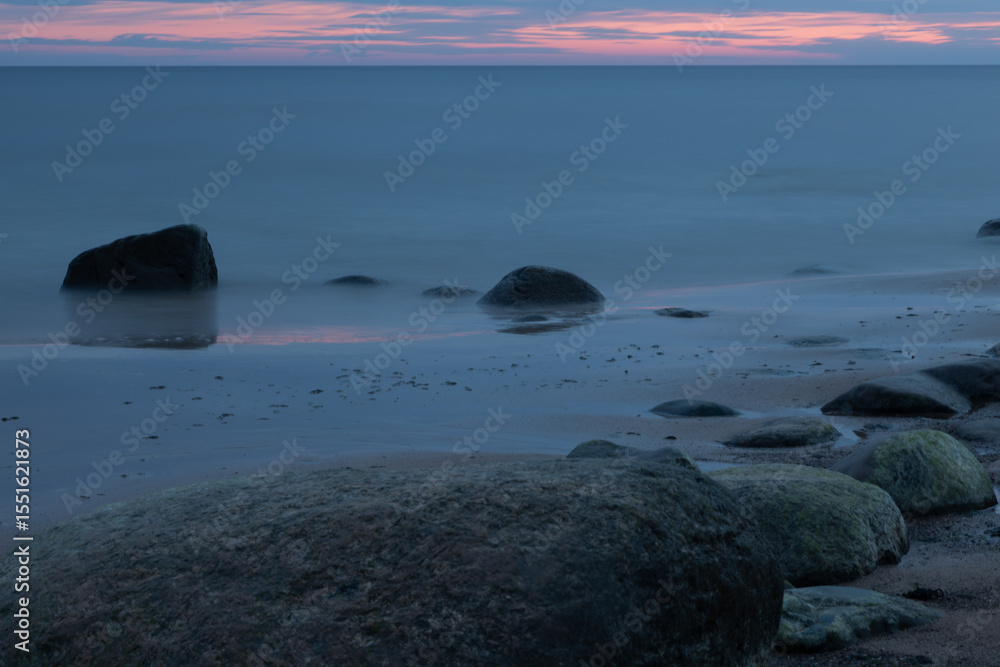 Obraz premium Serene Coastal View with Rocks and Calm Seascape at Sunset