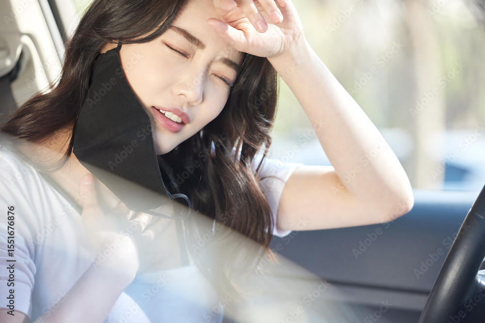 Fototapeta premium Young Woman Sitting in Car Removing Black Face Mask and Taking a Deep Breath Through the Window