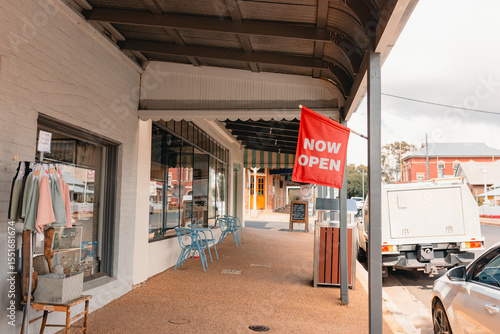 Vibrant red Now Open sign out front of gift shop in small regional town