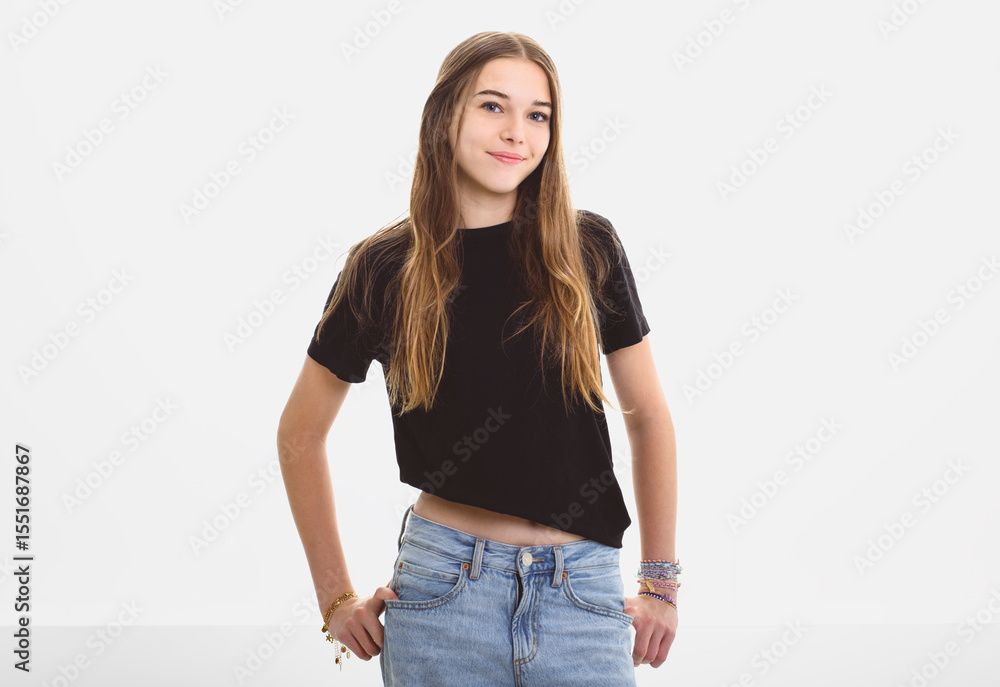 Obraz premium Portrait of teenage girl in casual black t-shirt on light background in studio.