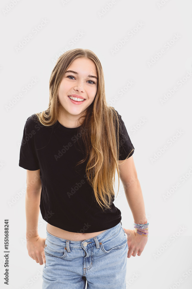 Fototapeta premium Portrait of teenage girl in casual black t-shirt on light background in studio.