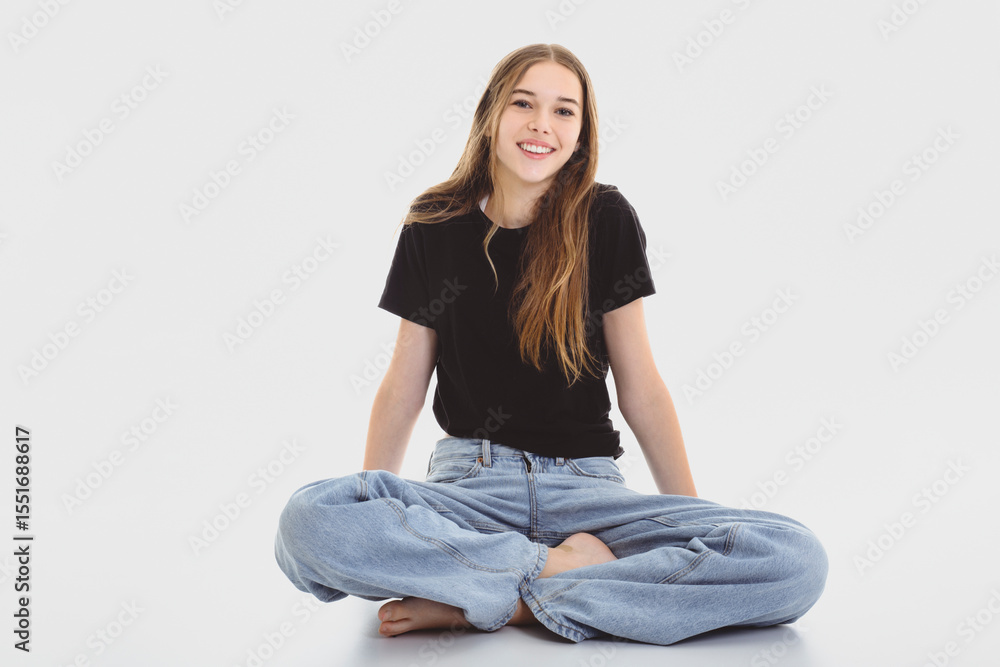 Portrait of teenage girl in casual black t-shirt on light background in studio. Portrait of teenage girl in casual black t-shirt on light background in studio.
