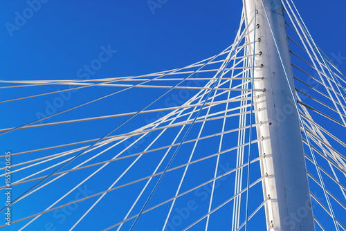 Fotografía Detailed view of cable-stayed bridge architecture with taut cables under blue sk