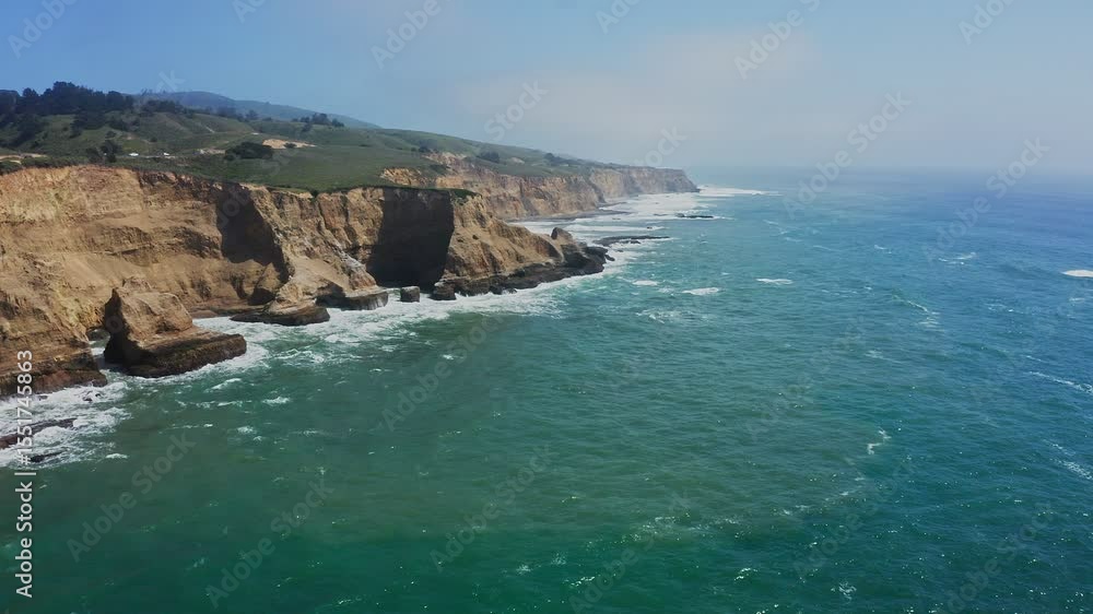 Aerial view of colorful cliffs and turquoise ocean near Highway 1 in Davenport, California. Breathtaking coastal scenery along the iconic Pacific Coast Highway on a sunny day Aerial view of colorful cliffs and turquoise ocean near Highway 1 in Davenport, California. Breathtaking coastal scenery along the iconic Pacific Coast Highway on a sunny day
