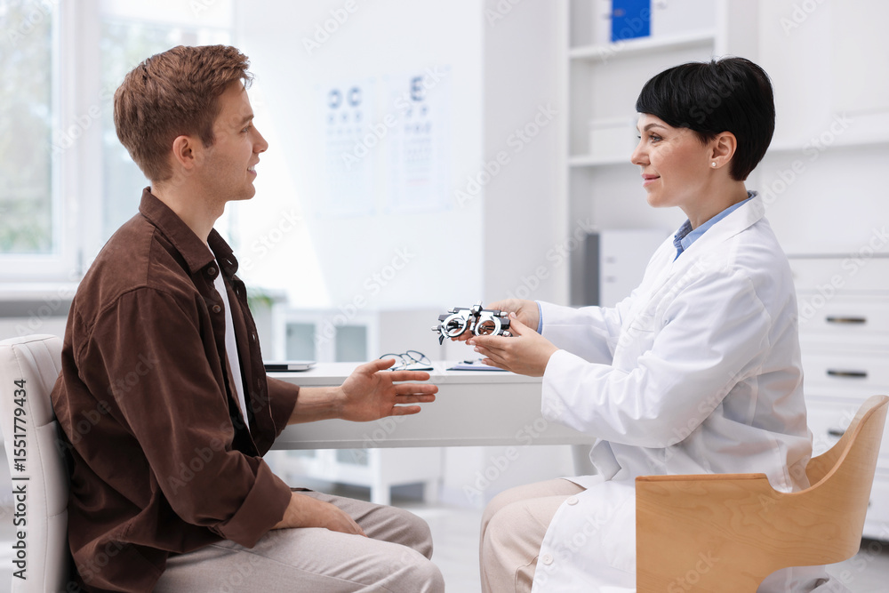 Obraz premium Ophthalmologist consulting young man at white table in clinic