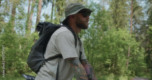 Wallpaper Mural Close-up of a young man with tattoos rising from handlebars and gazing into the distance. A symbolic gesture of determination and forward-looking eco mindset. High quality 4k footage Torontodigital.ca