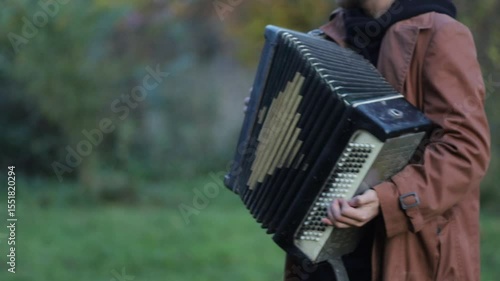 a man plays the accordion in the garden