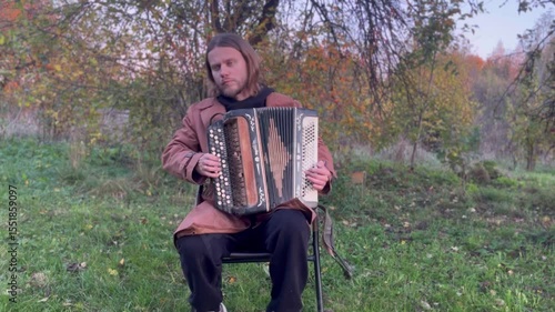 a man plays the accordion in the garden