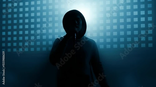 A striking silhouette of an individual dressed in a hoodie stands against a background of bright light and fog