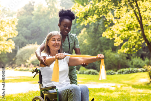 Photos Elderly woman in wheelchair with caregiver during park rehab