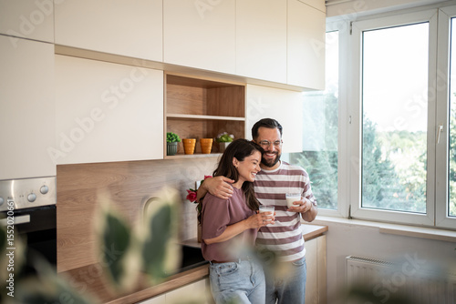 Behang Happy couple enjoying milk in modern kitchen