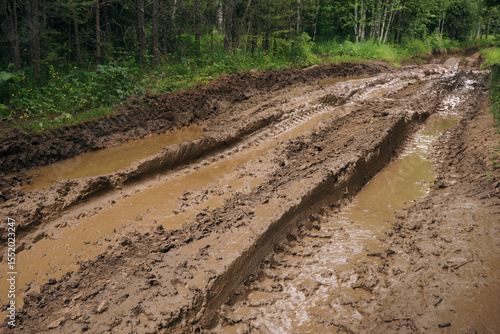 Canvas Print Muddy road with deep vehicle tracks after heavy rain and melting snow, Deep tire