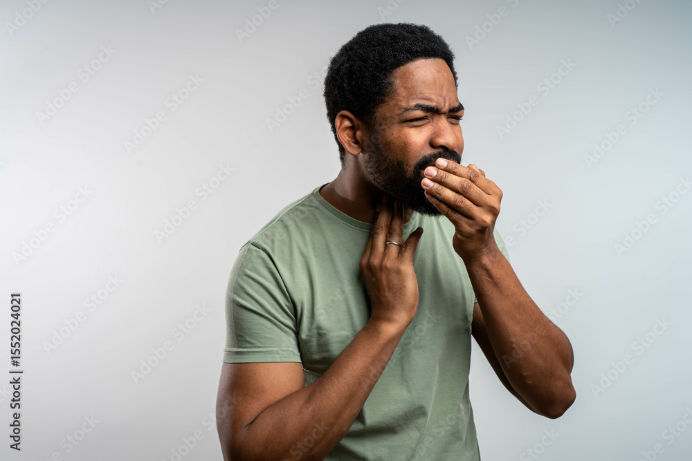 Young african man with sore throat holding neck in pain, uncomfortable expression on face, isolated studio portrait on white background