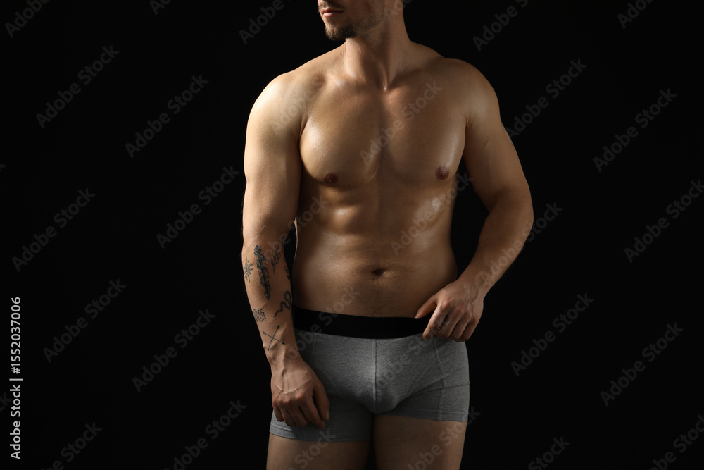 Fototapeta premium Young man in stylish light grey underwear on black background, closeup