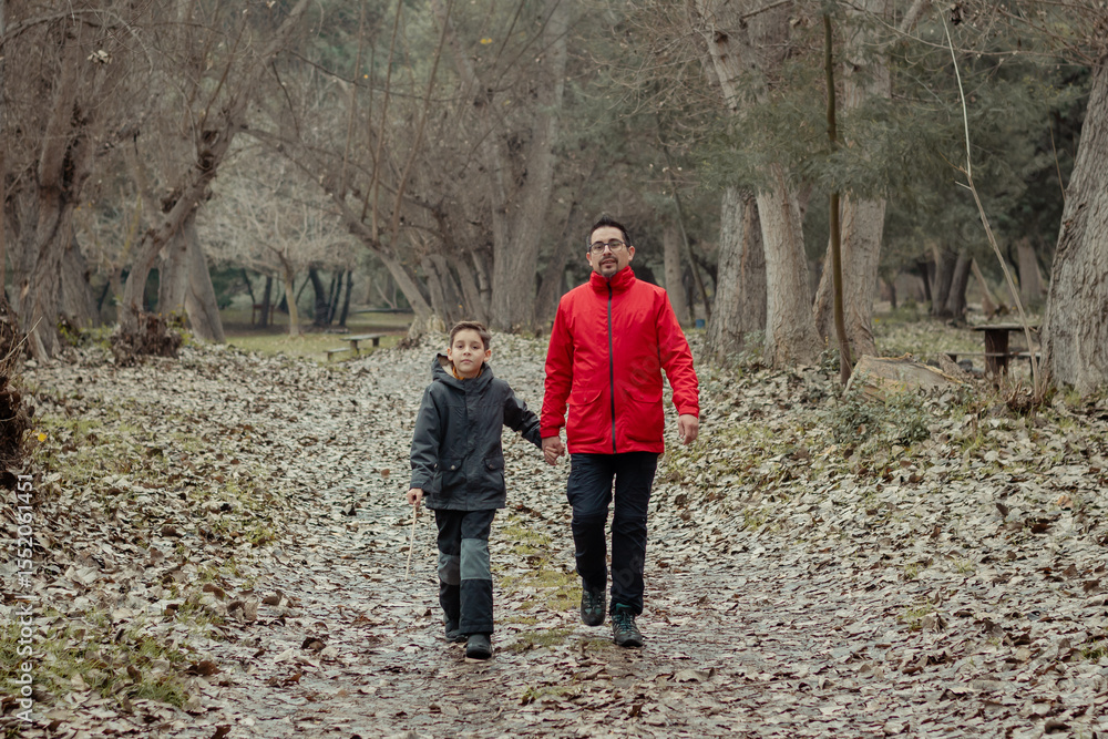 papá e hijo caminando juntos de la mano por un camino otoñal papá e hijo caminando juntos de la mano por un camino otoñal