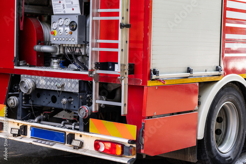 Red fire truck rear with equipment showing during an emergency response in a city street