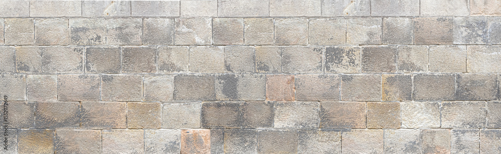Old stone brick wall forming a seamless texture background Old stone brick wall forming a seamless texture background