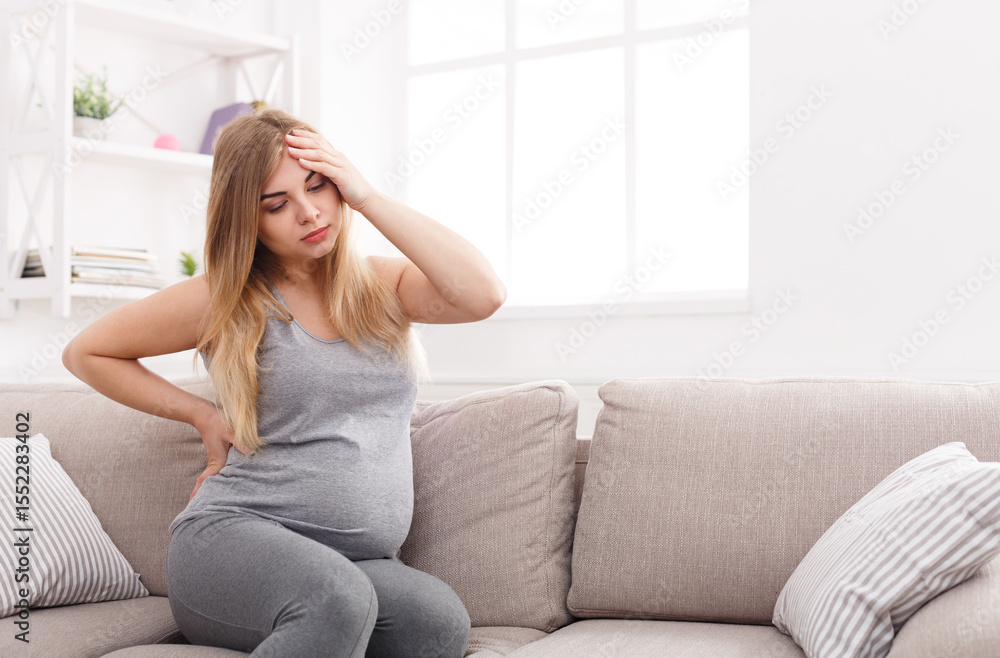 Young pregnant woman with headache and backache copy space. Pregnancy symptoms, healthcare concept Young pregnant woman with headache and backache copy space. Pregnancy symptoms, healthcare concept