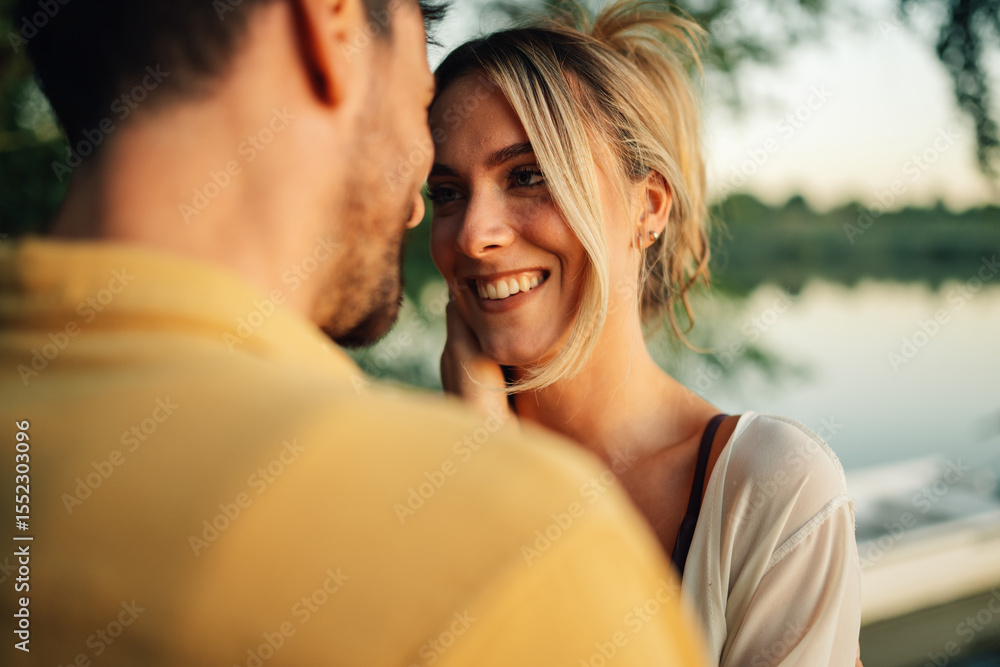 Fototapeta premium Happy couple sharing a romantic moment by the lake