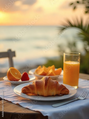 Fresh orange juice, a flaky croissant, and a hot cup of coffee make a delicious and healthy morning breakfast meal on the beach