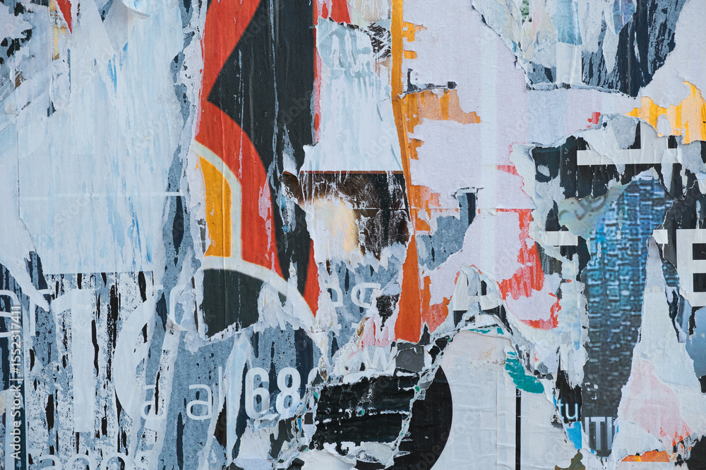 Fototapeta premium Abstract urban background. Old ripped torn posters texture background in city street