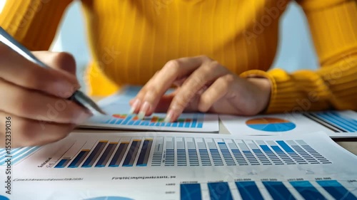 Charting Financial Analysis: A close-up view showcases a focused individual meticulously reviewing and annotating financial charts, emphasizing the meticulous process of data interpretation. 