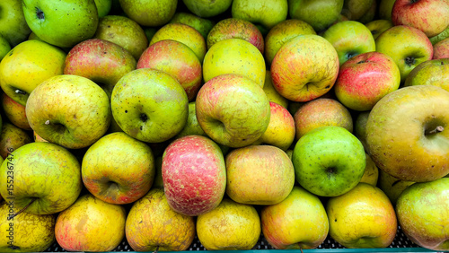 Fresh Apel Malang apples stacked in a market display, showcasing their natural red-green color and texture.