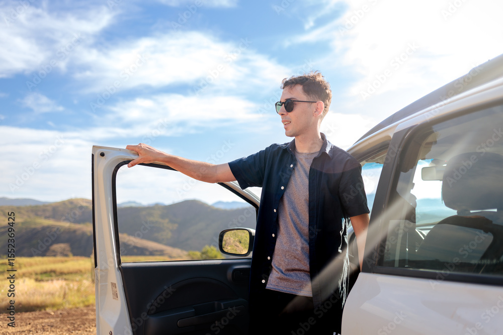 Young man stepping out of the car during a road trip, ready to explore the outdoors. A moment of freedom, excitement, and new travel experiences. Young man stepping out of the car during a road trip, ready to explore the outdoors. A moment of freedom, excitement, and new travel experiences.