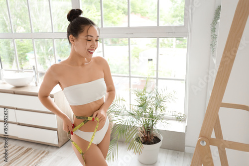 Young Asian woman measuring...