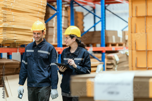 Young employee checking stock In a large cardboard factory