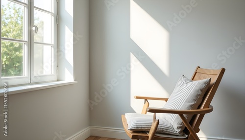 A wooden chair with a striped cushion sits in a corner of a room, casting a shadow on the wall