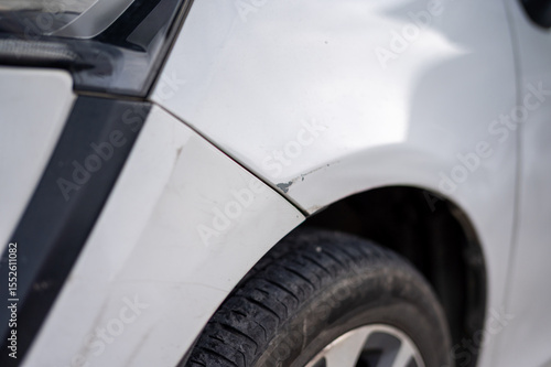 Fotografie Chipped paint and slight dent on car fender above tire