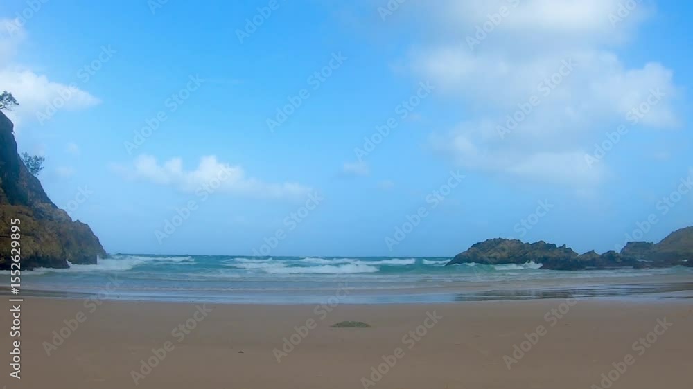 Sandy Beach with Ocean Waves and Rocky Cliffs – Scenic Coastal View under Clear Blue Sky Sandy Beach with Ocean Waves and Rocky Cliffs – Scenic Coastal View under Clear Blue Sky