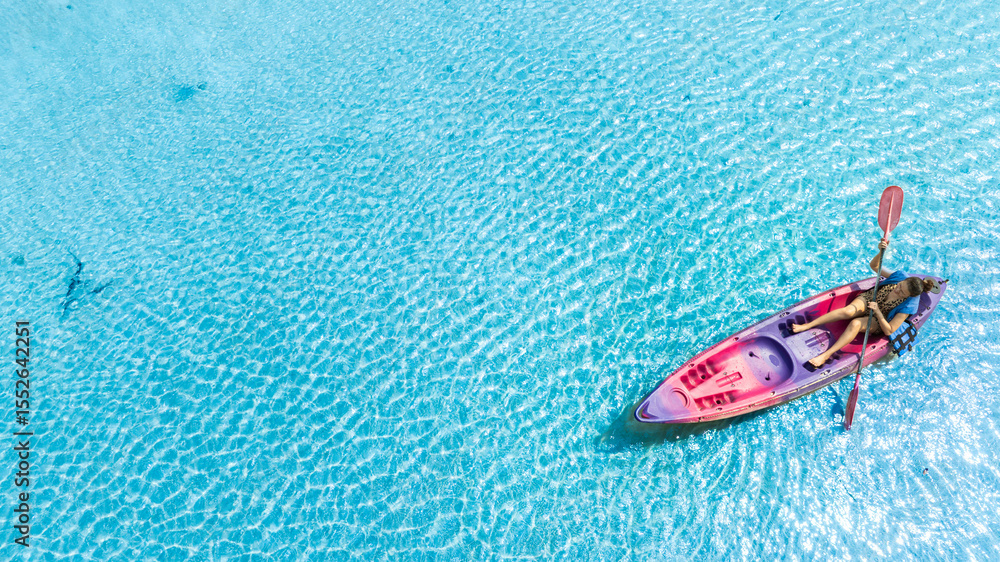 Fototapeta premium Aerial view of a kayak in the blue sea .Woman kayaking She does water sports activities.
